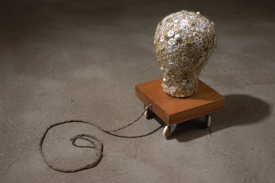Lisa Kokin, Forget the Story, 2004. Millinery form, buttons, thread, wood, casters, rope, 14 x 8.5 x 40 in.